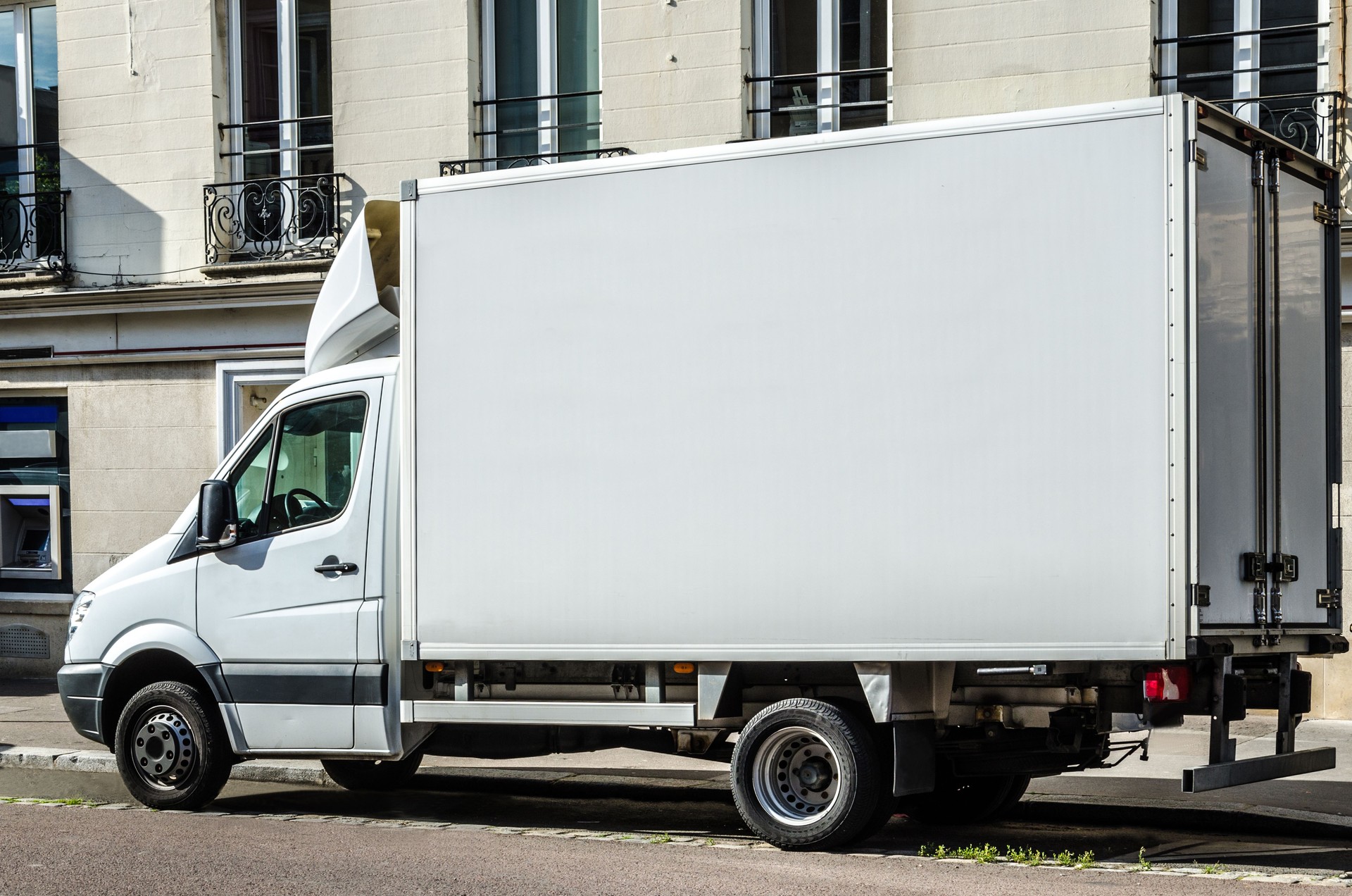 Blank white van or truck with copy space parked in a street